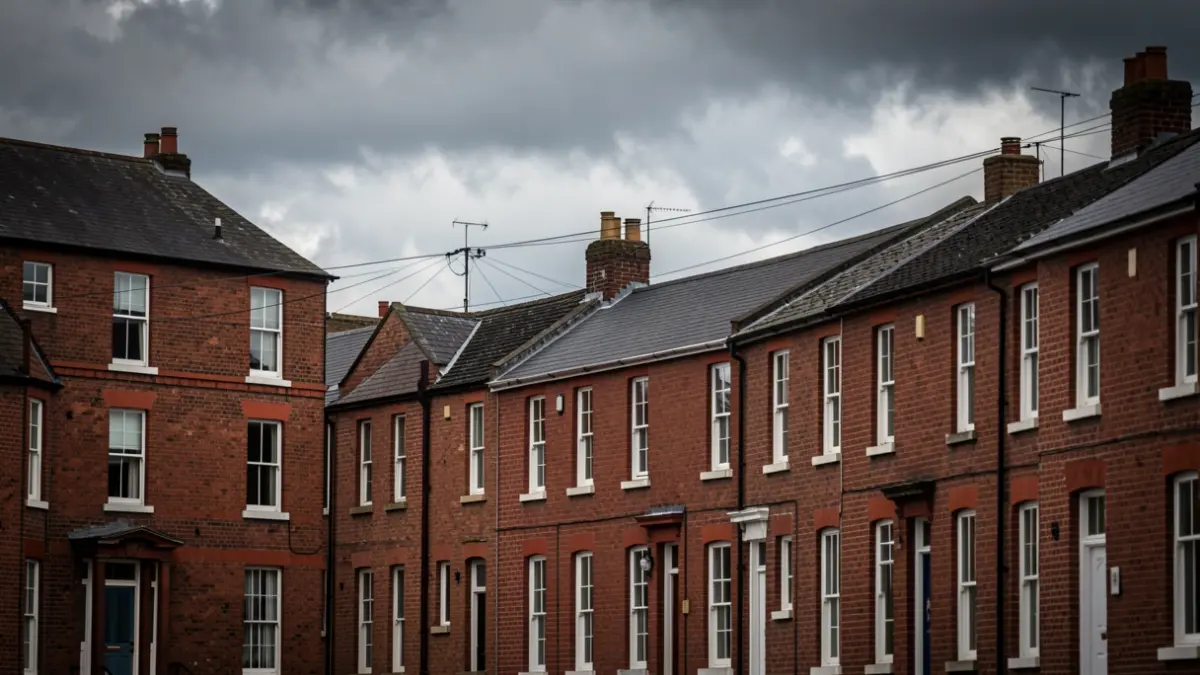 Red-brick houses under a dramatic, cloudy North West England sky.
